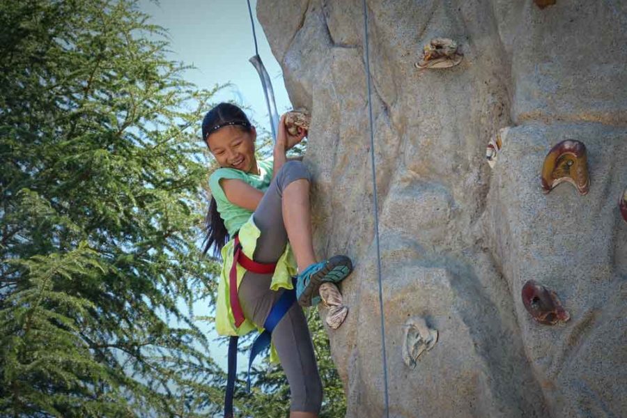 Girl climbing rock wall at Dorris-Eaton summer camp